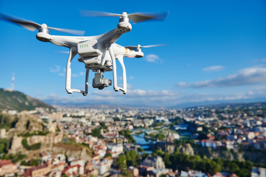 che cosa è un drone, foto di undrone che sorvola un paesaggio